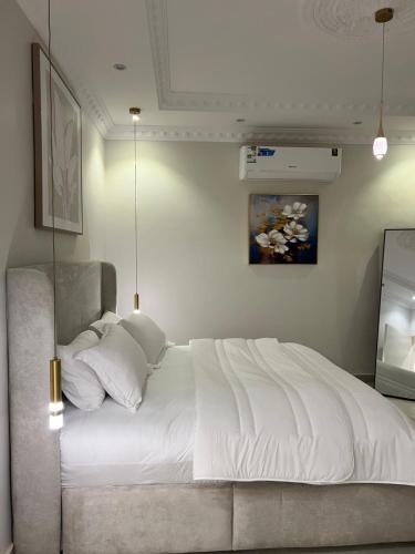 Un dormitorio con una gran cama blanca y un televisor. en Rfaa Suites, en Medina