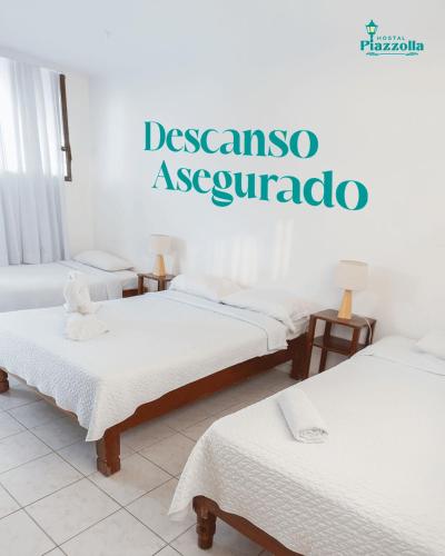 a room with three beds with a sign on the wall at HOSTAL PIAZZOLLA in Manta