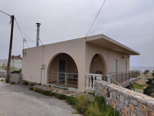 a small white building with a stone wall at Sea Sight Vibes in Frangokastello