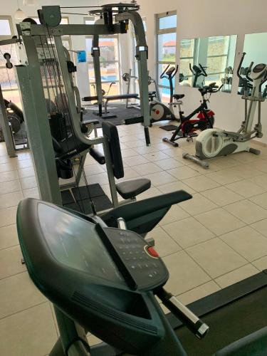a gym with several treadmills and exercise bikes at Boho Bay Apartment in Akanthou