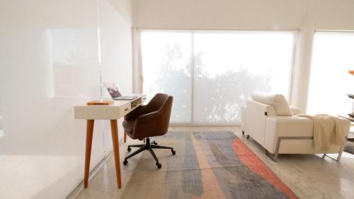 a living room with a desk and a chair at Casita Perla Sustainable Villa with Mountain View, Long Pool, King, Grill in Texcalpan
