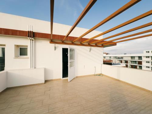 a large balcony with white walls and a wooden ceiling at Luxury studio, Iskele, Cyprus in Iskele