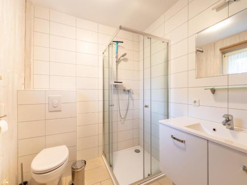 a bathroom with a shower and a toilet and a sink at Ferienhaus mit einladendem Platzangebot in Granzow
