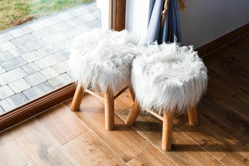 two chairs covered in white fur sitting next to a window at Aleksandrówka in Szlembark