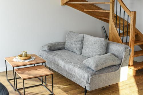 a living room with a gray couch and a wooden table at Aleksandrówka in Szlembark