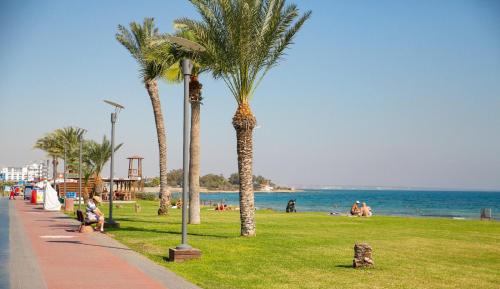 a park with palm trees and people on the beach at Luxury studio, Iskele, Cyprus in Iskele