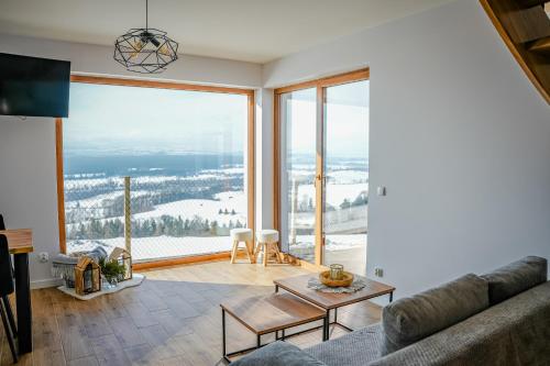 a living room with a couch and a large window at Aleksandrówka in Szlembark