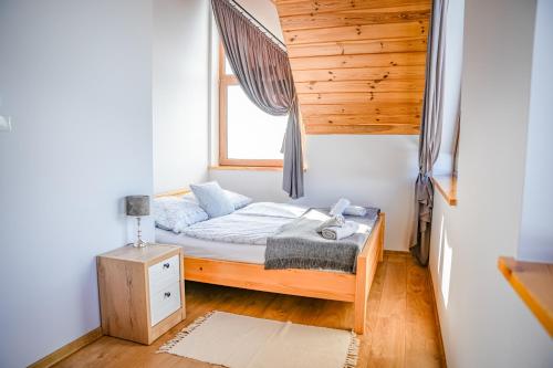 a small bedroom with a bed and a window at Aleksandrówka in Szlembark