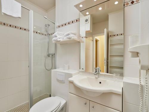 a white bathroom with a sink and a toilet at Appartements im Freizeitpark Weissenhäuser Strand in Weissenhäuser Strand