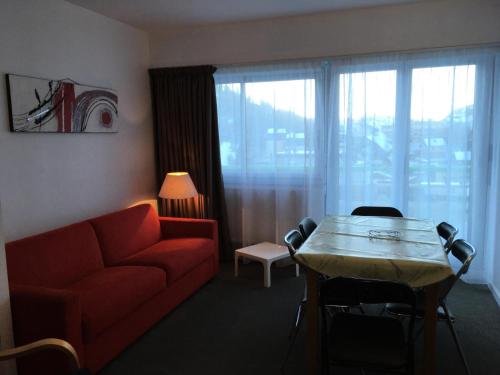 un salon avec un canapé rouge et une table dans l'établissement Résidence SANCTUS - Studio pour 6 Personnes MAE-9044, à Gourette