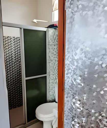 a bathroom with a toilet and a glass wall at Temporada no Atalaia in Salinópolis