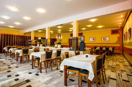 a restaurant with tables and chairs and yellow walls at OW Inter Piast własna plaża z kąpieliskiem i przystań in Dąbrówno