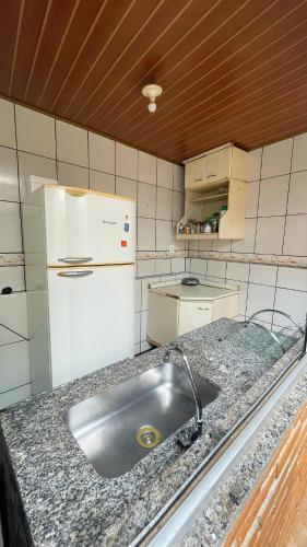 a kitchen with a sink and a white refrigerator at Hostel Diamante in Diamantina