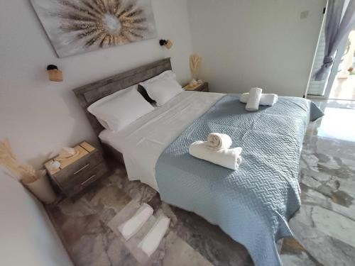 a bedroom with a bed with two towels on it at Kalimera apartments in Marathias