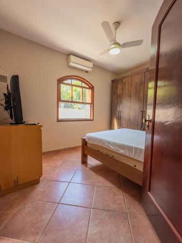 a bedroom with a bed and a flat screen tv at Casa de Campo I Cond Ninho Verde II in Pardinho