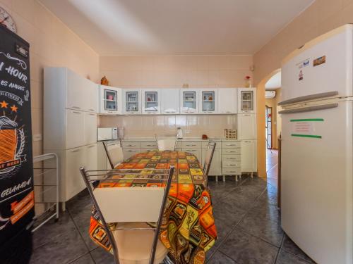 a kitchen with a table with chairs and a refrigerator at Casa de Campo I Cond Ninho Verde II in Pardinho