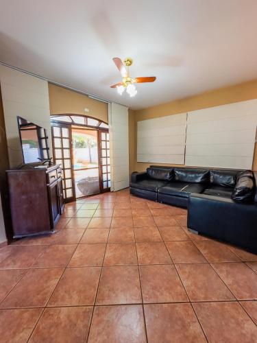 a living room with a couch and a ceiling fan at Casa de Campo I Cond Ninho Verde II in Pardinho
