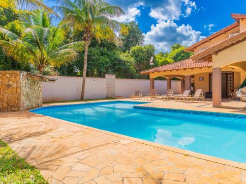 a swimming pool with a patio and a house at Casa de Campo I Cond Ninho Verde II in Pardinho