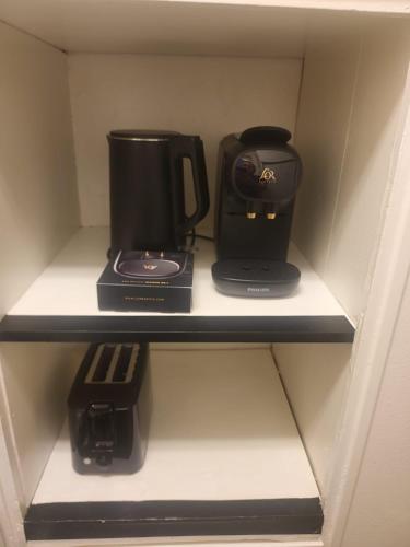 a cupboard with two coffins and a coffee maker at Borås Studio Apartment in Borås