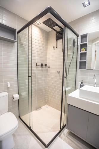 a bathroom with a shower and a toilet and a sink at Arpoar Flat 118 - De frente para o mar in João Pessoa