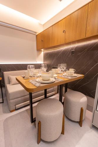 a dining room with a table with wine glasses on it at Arpoar Flat 118 - De frente para o mar in João Pessoa