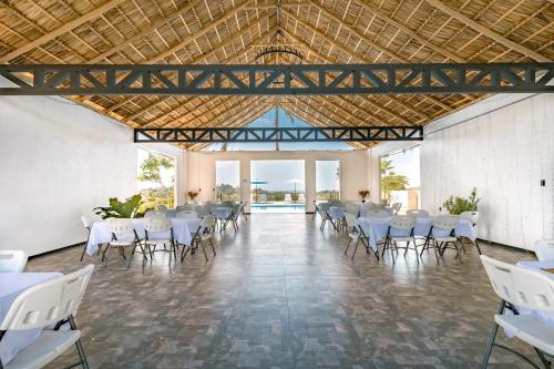 a large banquet hall with white tables and chairs at Tardes Doradas in Quepos