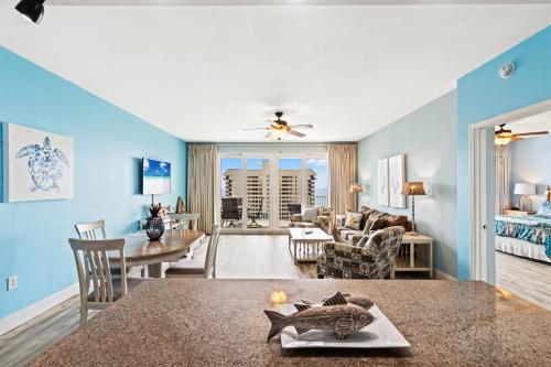 Una sala de estar con paredes azules y un comedor. en Blue Turtle at Laketown, en Panama City Beach