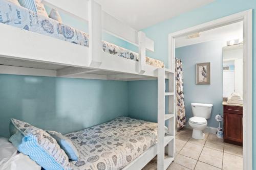 Un dormitorio con dos literas y un baño. en Blue Turtle at Laketown, en Panama City Beach