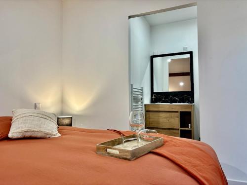 Schlafzimmer mit einem Bett mit einer Flasche und einem Spiegel in der Unterkunft Le SILVA Centre ville Lumineux Wifi et Netflix in Périgueux