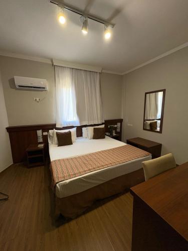 a bedroom with a large bed with a window at Class Hotel Passos in Passos