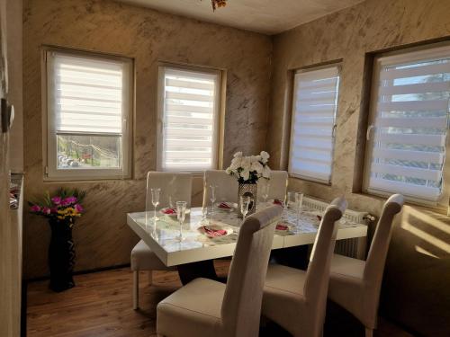 a dining room with a table and chairs and windows at Christian Dior Lazarevac in Lazarevac