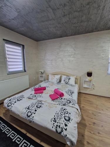a bedroom with a large bed with pink pillows at Christian Dior Lazarevac in Lazarevac