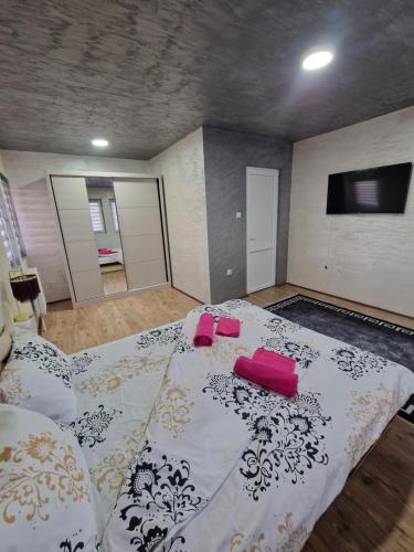 a room with a bed with two pink pillows on it at Christian Dior Lazarevac in Lazarevac