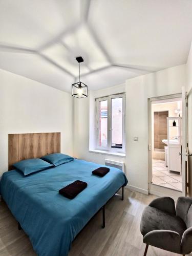- une chambre avec un lit bleu et une chaise dans l'établissement Tour Est - T2 entre Cité Médiévale et Bastide, à Carcassonne