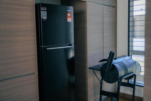 a black refrigerator in a kitchen next to a table at Bandar Botanic Klang lux bungalow Home stay in Pelabohan Klang