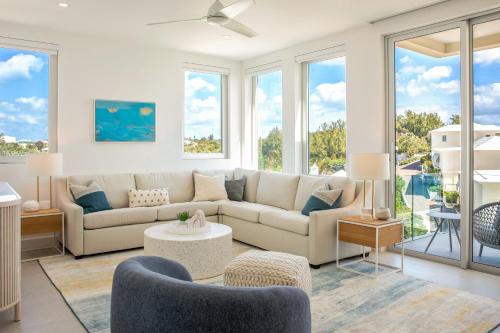 a living room with a couch and chairs and windows at Azura Bermuda in Bermuda