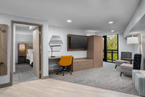 a room with a bed and a desk and a television at Holiday Inn Express Hilton Head Island by IHG in Hilton Head Island