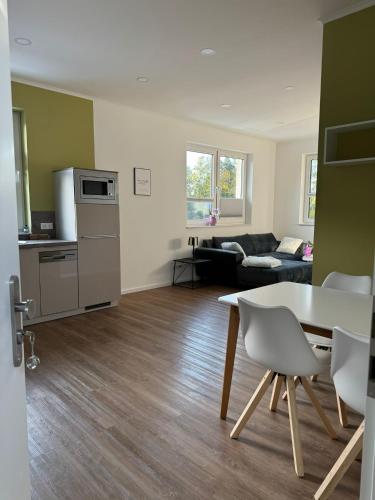 an empty living room with a table and a kitchen at Chalet Mühlenhof in Hessisch Oldendorf