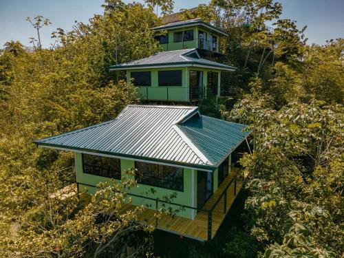 a house on top of a hill with trees at Tardes Doradas in Quepos