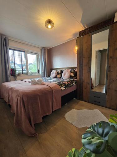 a bedroom with a large bed with a large window at Tip Top Vakantie Huis in Vlissingen