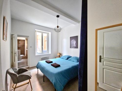 - une chambre avec un lit bleu et une chaise dans l'établissement Tour Ouest - T2 entre Cité Médiévale et Bastide, à Carcassonne