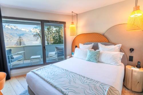 a hotel room with a bed and a balcony at Black Bass Hotel in Sévrier