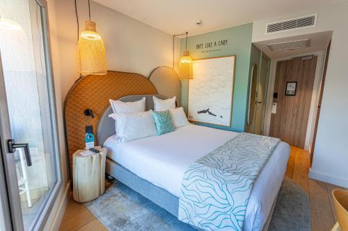 a hotel room with a bed and a suitcase at Black Bass Hotel in Sévrier