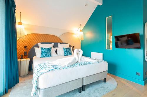 a bedroom with a large bed with blue walls at Black Bass Hotel in Sévrier