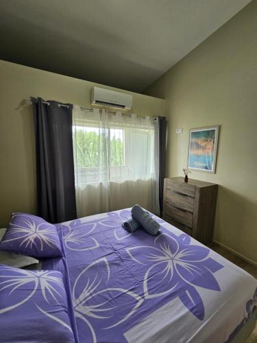 a bedroom with a purple bed and a window at F2 PAPEETE CITY CENTER in Papeete