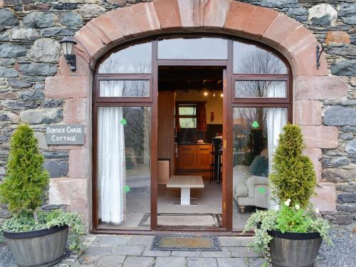 an entrance to a building with an arched doorway at Doddick Chase Cottage - Uk1363 in Threlkeld