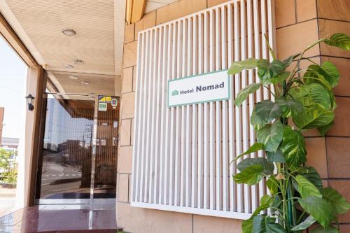 a sign on the side of a building with a plant at Hotel Nomad - Vacation STAY 61779v in Hitachi