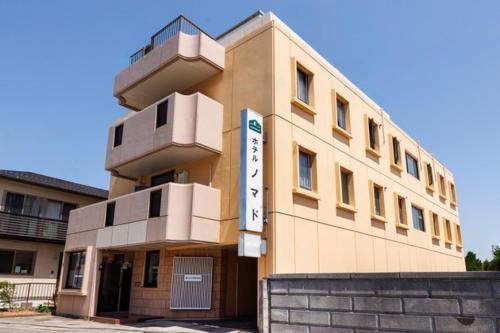 a building with a sign on the side of it at Hotel Nomad - Vacation STAY 61779v in Hitachi