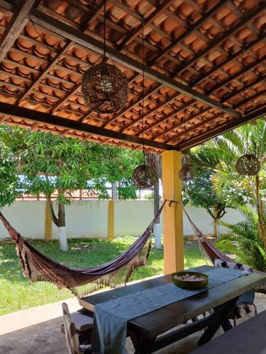 a patio with a hammock and a table and chairs at Pousada Graboschii, 300mt da praia do Refúgio in Aracaju