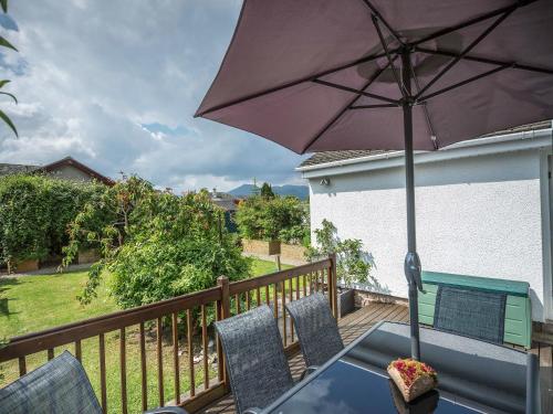 a patio table with an umbrella on a deck at Briargarth in Keswick